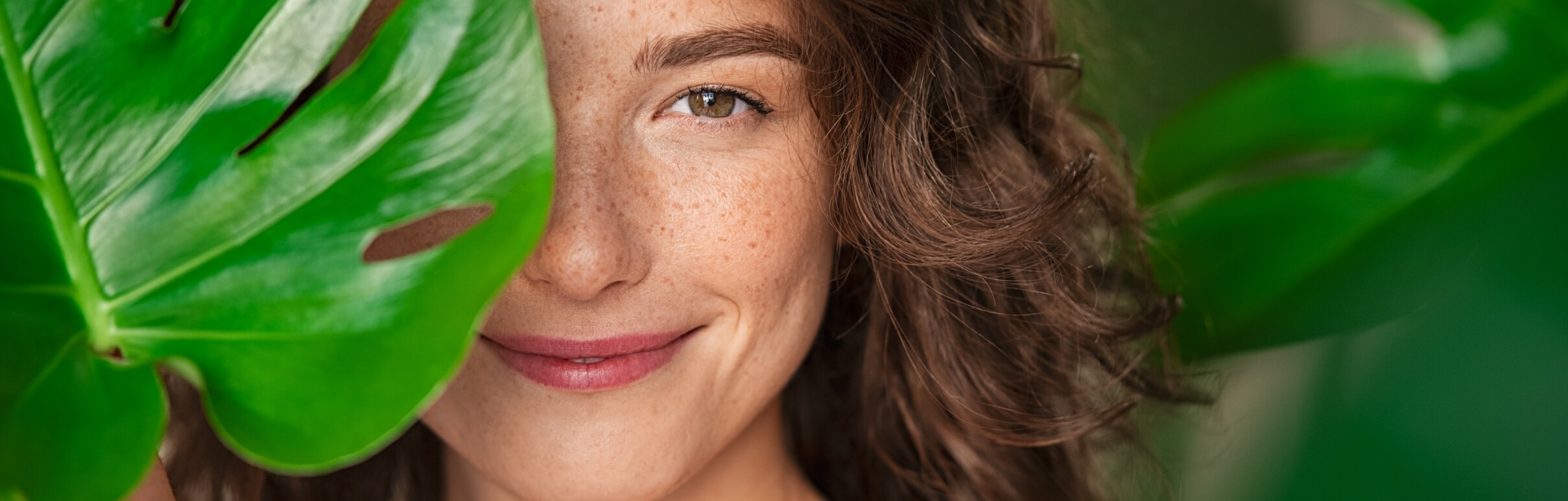 beauty-natural-woman-covering-her-face-with-tropic-2023-11-27-05-03-30-utc-1
