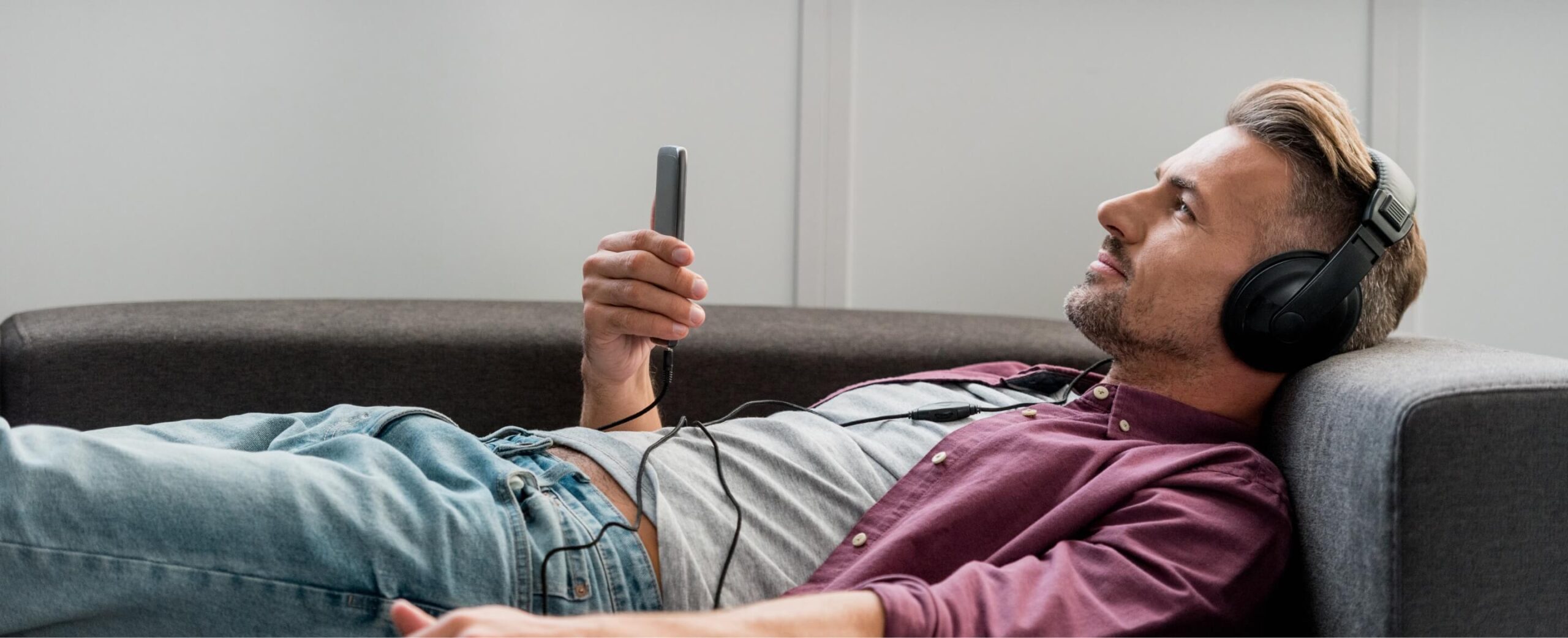 happy-man-with-smartphone-listening-music-while-la-2022-12-16-19-39-29-utc-1-scaled